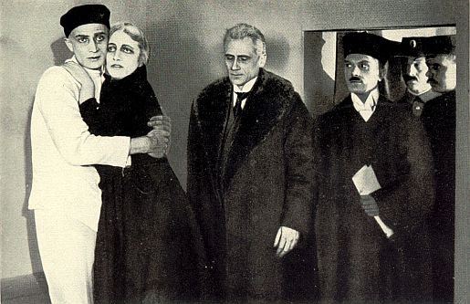 "Opfer der Gesellschaft" (1918): Szene mit Conrad Veidt (l.) als der zum Tode verurteilte, einstige Staatsanwalt Chrysander und Anneliese Halbe als dessen Ex-Verlobte; Quelle: virtual-history.com aus "Vom Werden deutscher Filmkunst/1. Teil: Der stumme Film" von Dr. Oskar Kalbus (Berlin 1935, S. 30); Lizenz: gemeinfrei